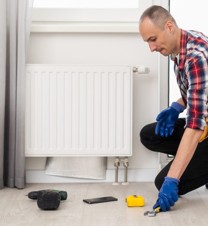 Central heating mechanic and handyman fixing home radiator, gas crisis and seasonal issues.