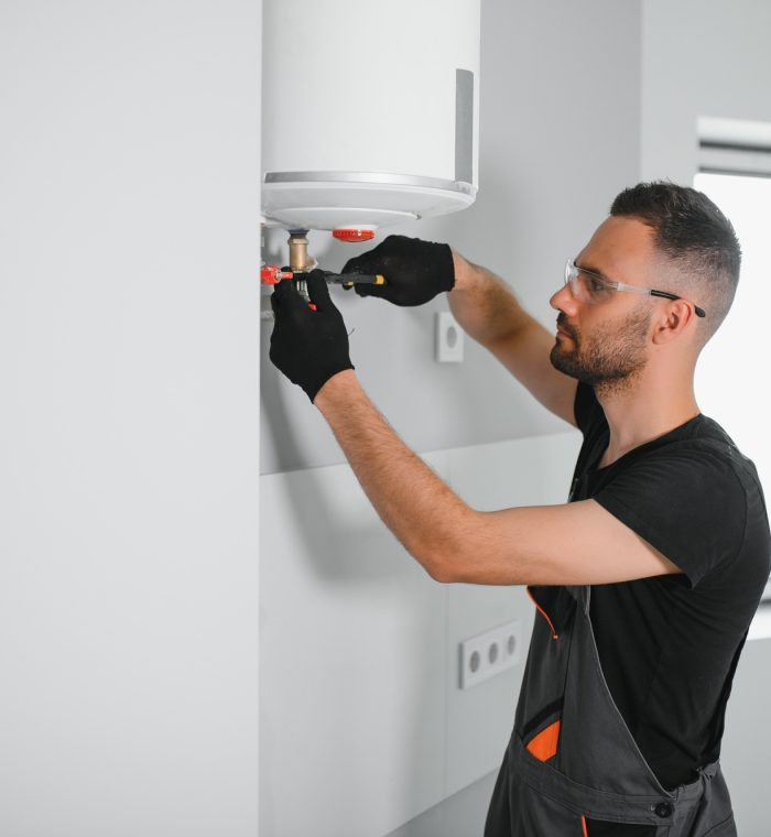 Professional plumber checking a boiler and pipes, boiler service concept